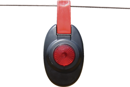 Patriot fence warning light hanging on a wire against a white background