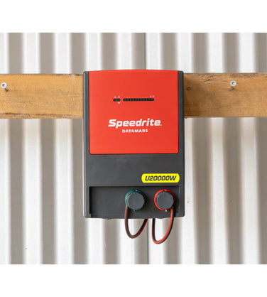 Speedrite U20000W electric Fence Unigizer mounted on barn wall at cattle farm and connected to electric fencing